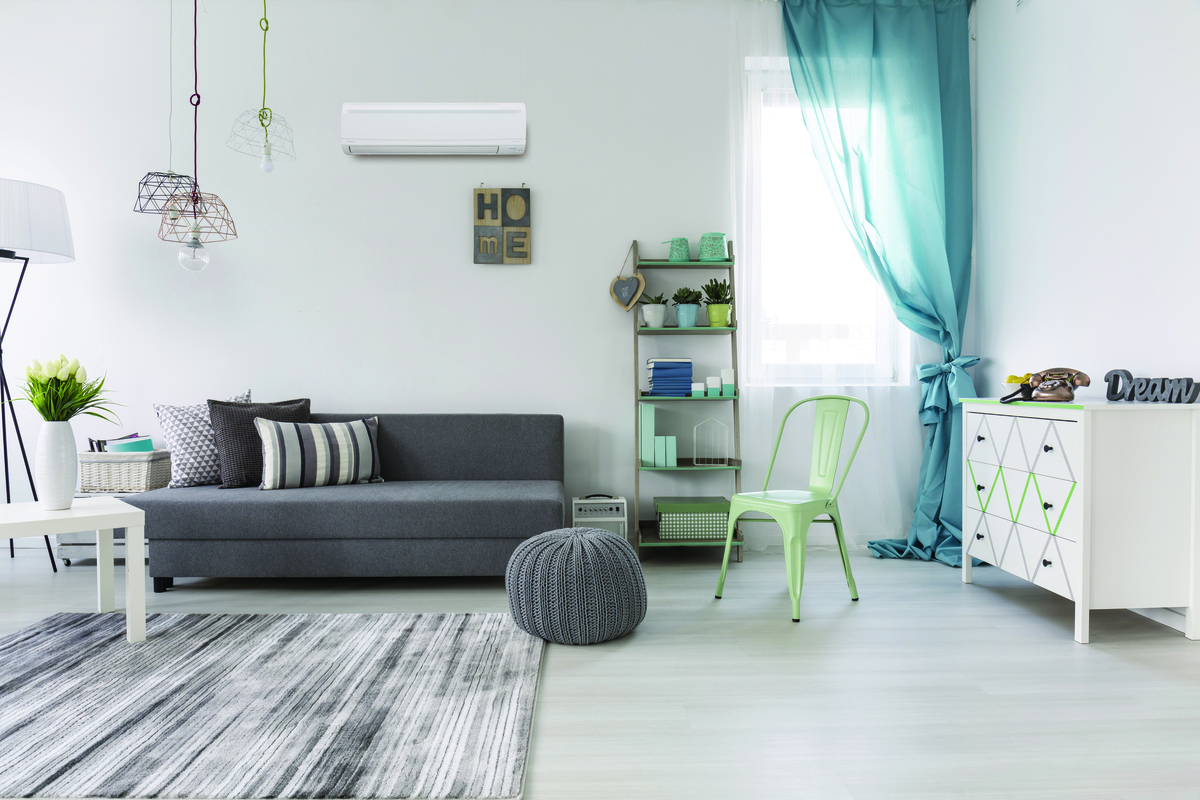 Indoor living room with modern furniture and a wall-mounted ductless mini-split air conditioning unit providing home comfort